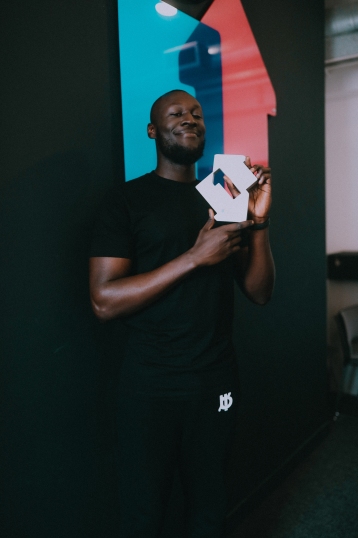 Stormzy with his Official Number 1 Single Award for Vossi Bop (Credit: Kaylum Dennis)